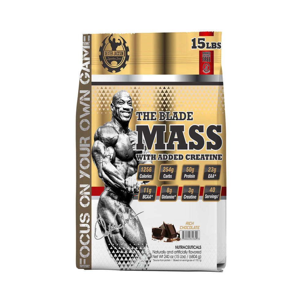 A bag of The Blade Mass supplement, 15 lbs, in chocolate flavor. The packaging features a muscular bodybuilder graphic, gold and white color scheme, and nutritional badges on the front.