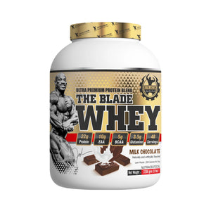 A white plastic tub of The Blade Whey protein powder in Milk Chocolate flavor, featuring a gold and black label with a muscular bodybuilder graphic.