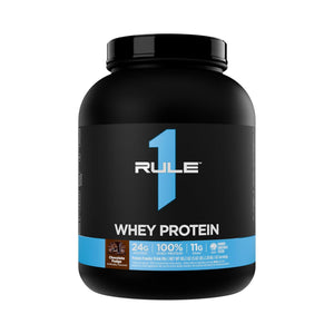A black tub of RULE 1 Whey Protein in Chocolate flavor, featuring a black label with a prominent blue number 1 and light blue accents.