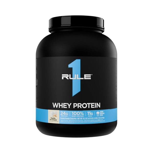 A black plastic tub of Rule 1 Whey Protein Vanilla Ice Cream flavor, featuring a black label with a prominent blue number 1 and a blue band at the bottom.